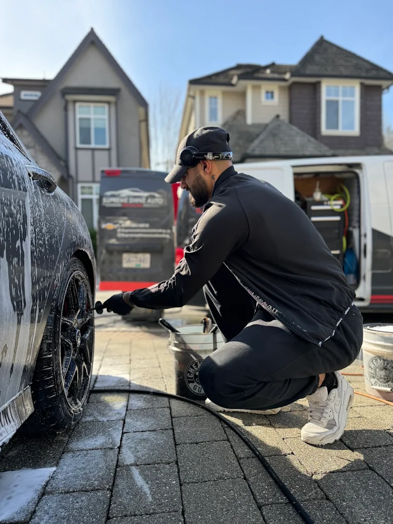 Detailer washing a vehicle window